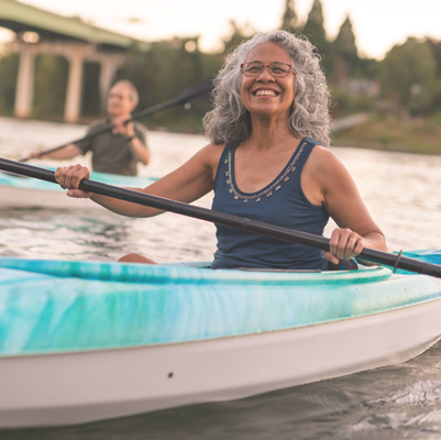Elderly woman kayaking along river Elderly woman kayaking along river